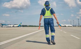 signalman-with-wands-going-along-the-runway-2023-11-27-05-14-03-utc