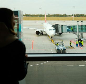 woman-traveler-standing-near-panoramic-big-window-2023-11-27-05-36-04-utc